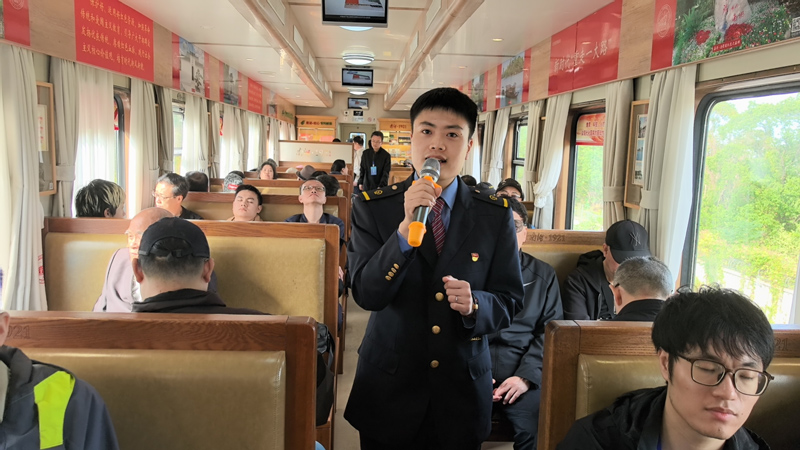 “南湖·1921”紅色旅游列車宣講員向采訪團和旅客講解紅色歷史故事。崔偉攝