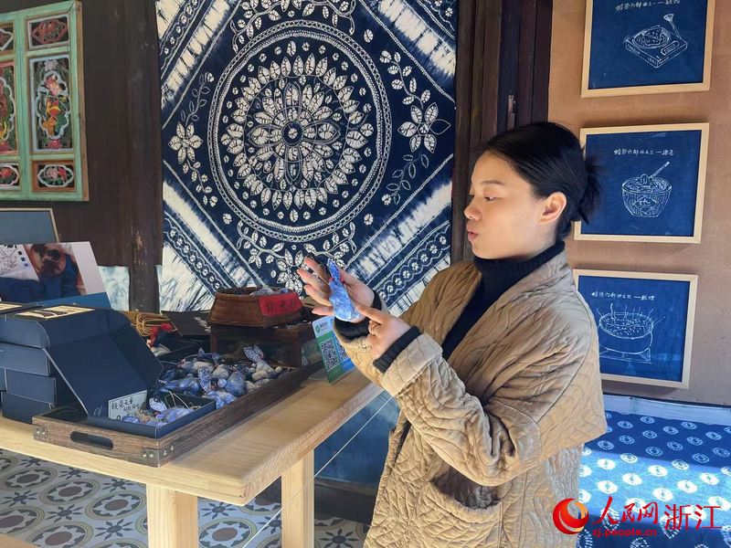 李祖村創(chuàng)客樓沙漠霜向游客介紹自己的扎染作品。人民網(wǎng)記者 王麗瑋攝