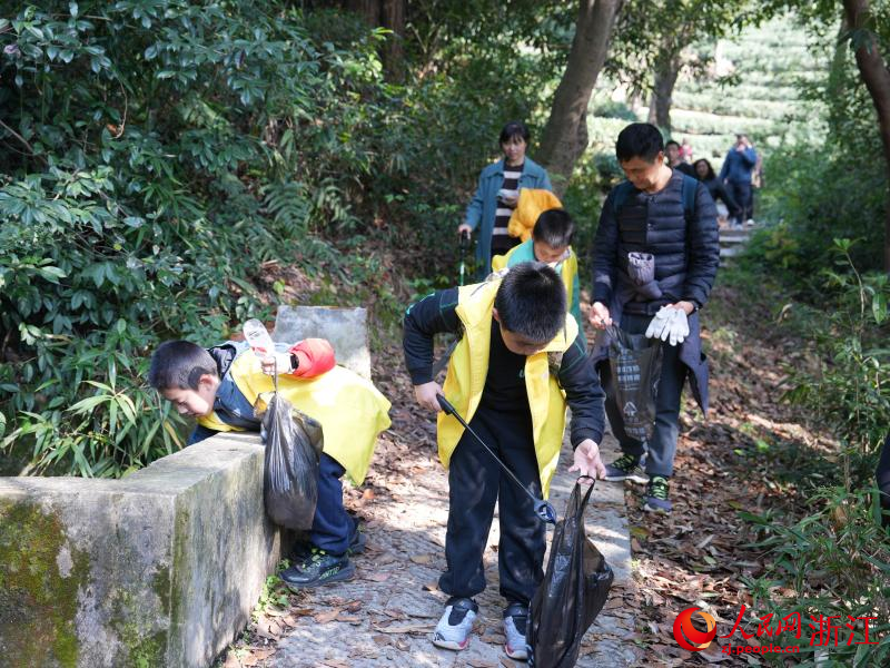 孩子們一邊爬山一邊撿拾垃圾。人民網(wǎng) 程欣攝