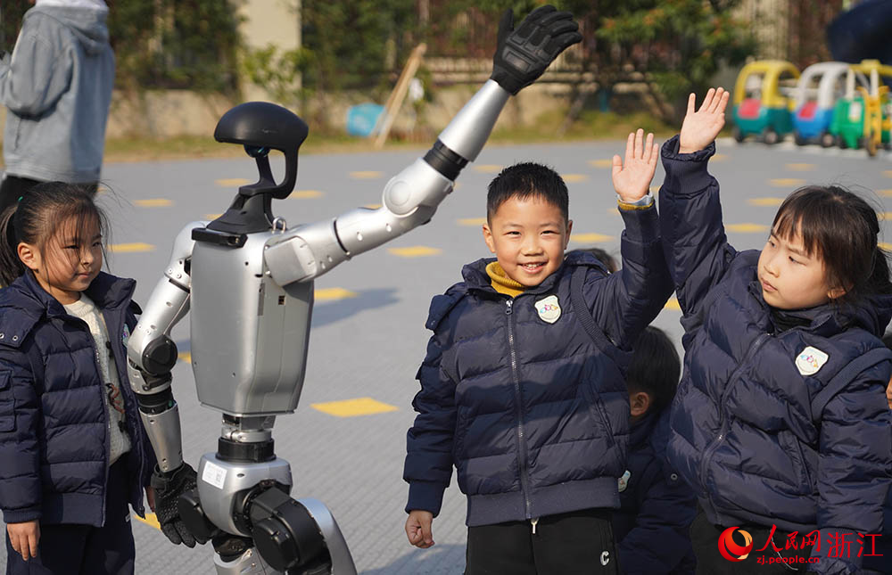 在寧波市江北區(qū)慈城懷之幼兒園，孩子們和人形機(jī)器人同步動(dòng)作。人民網(wǎng) 章勇濤攝